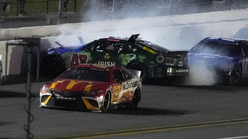 Bubba Wallace (23) gets by as Ricky Stenhouse Jr. (47) crashes during the NASCAR Daytona 500 auto race Sunday, Feb. 20, 2022, at Daytona International Speedway in Daytona Beach, Fla. (AP Photo/Chris O'Meara)