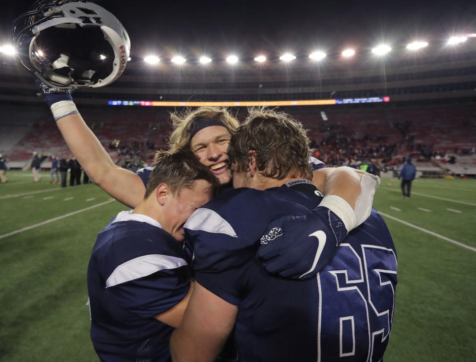 Lake Country Lutheran's Jack Leverenz, center, is embraced by Will Brazgel, left, and Noah Vanderberg after their WIAA Division 5 championship game Thursday, Nov. 21, 2019, at Camp Randall Stadium in Madison. Lake Country Lutheran beat Stratford 22-13.