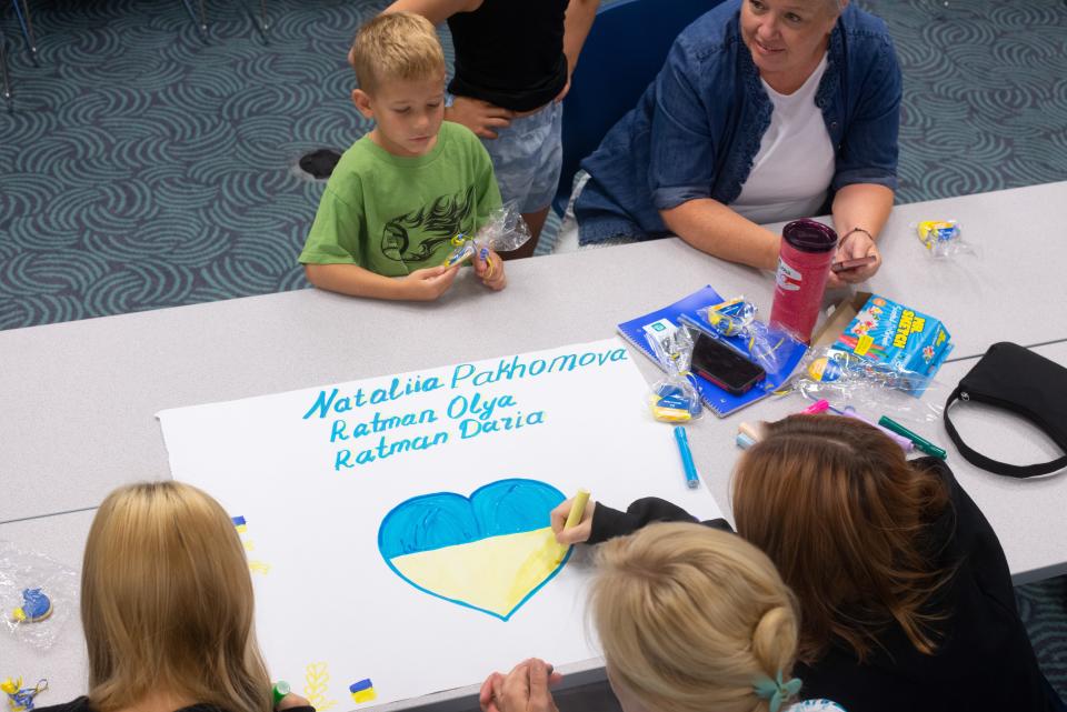 Families from Ukraine draw a heart in the colors of their country's flag as part of an activity for Topeka USD 501's orientation event.