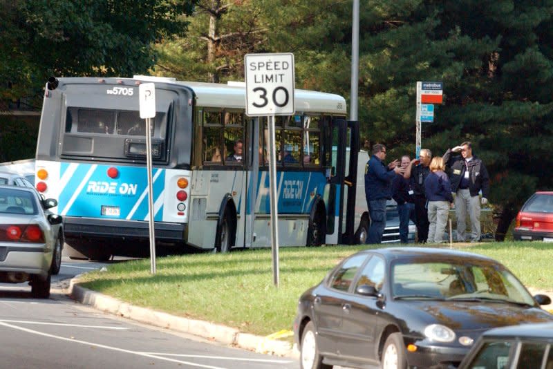 Law enforcement officials search the scene of a shooting in Aspen Hill, Md., on October 22, 2002, where 35 year-old Conrad Johnson, a bus driver who was getting ready to start his route, was shot and killed. On October 24, 2002, police arrested two suspects in a three-week series of Washington-area sniper attacks that killed 10 people and wounded three others. File Photo by Chris Corder/UPI