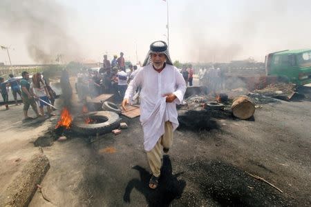 Iraqi protesters burn tires and block the road at the entrance to the city of Basra, Iraq July 12, 2018. REUTERS/Essam al-Sudani
