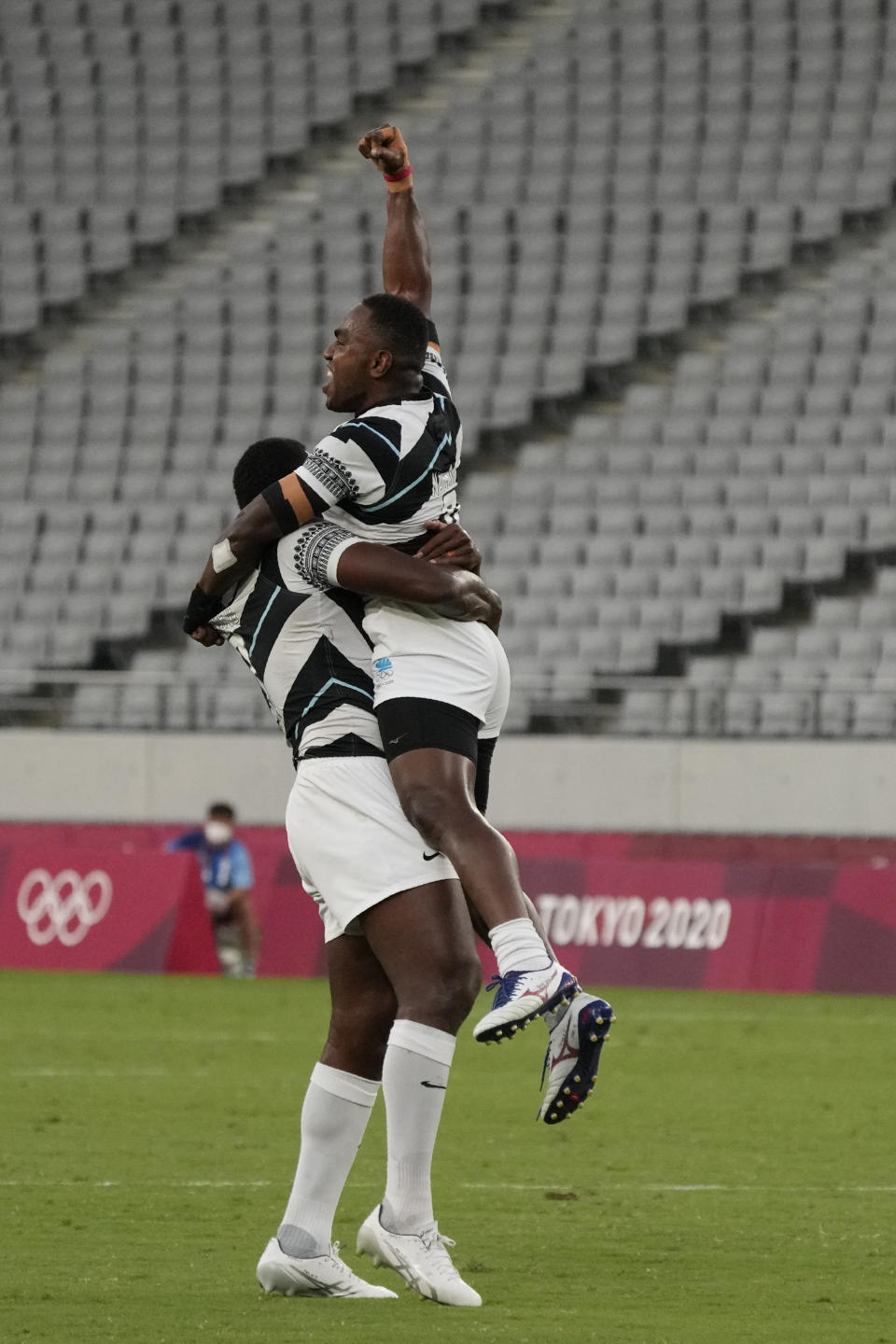 Fiji's Kalione Nasoko lifts teammate Waisea Nacuqu as they celebrate winning gold over New Zealand in men's rugby sevens at the 2020 Summer Olympics, Wednesday, July 28, 2021 in Tokyo, Japan. (AP Photo/Shuji Kajiyama)