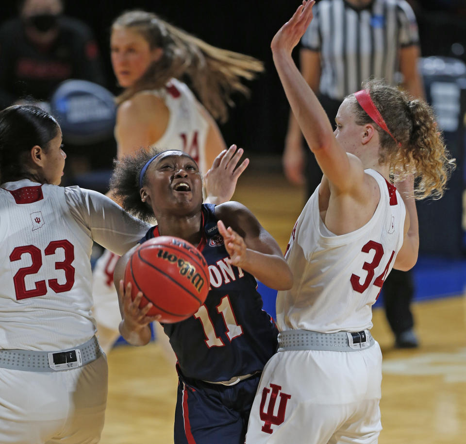 Belmont guard Destinee Wells (11) drives between Indiana guard Tori Campbell (23) and guard Grace Berger (34) during the first half of a college basketball game in the second round of the NCAA women's tournament at the Greehey Arena in San Antonio on Wednesday, March 24, 2021. (AP Photo/Ronald Cortes)