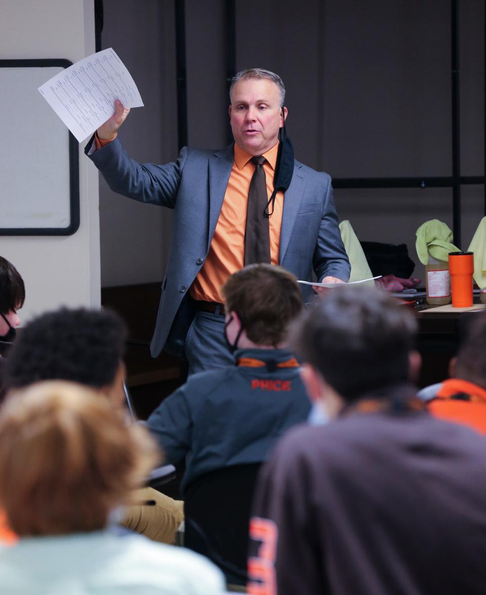 DeSales High School new head football coach Mike Jackson hands out forms to the school's football team in their auditorium ahead of a press conference to announce his appointment in Louisville, Ky. on Nov. 15, 2021.