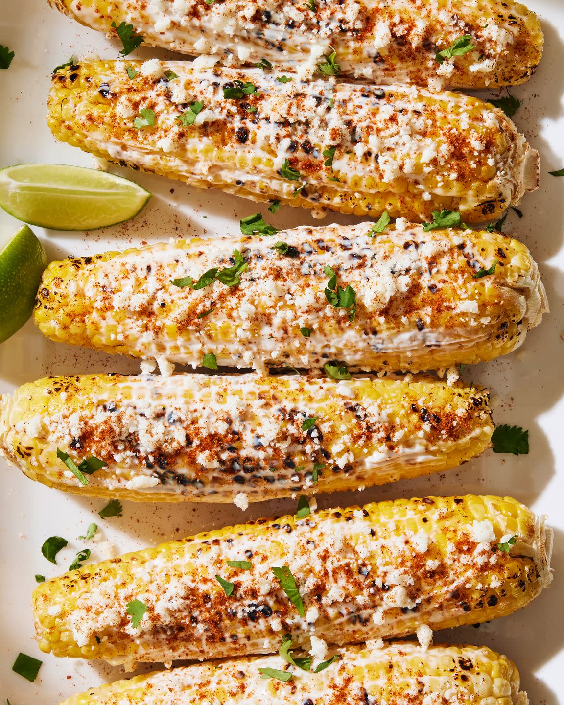 grilled corn topped with a creamy mixture, cotija cheese, chili powder, cilantro and lime