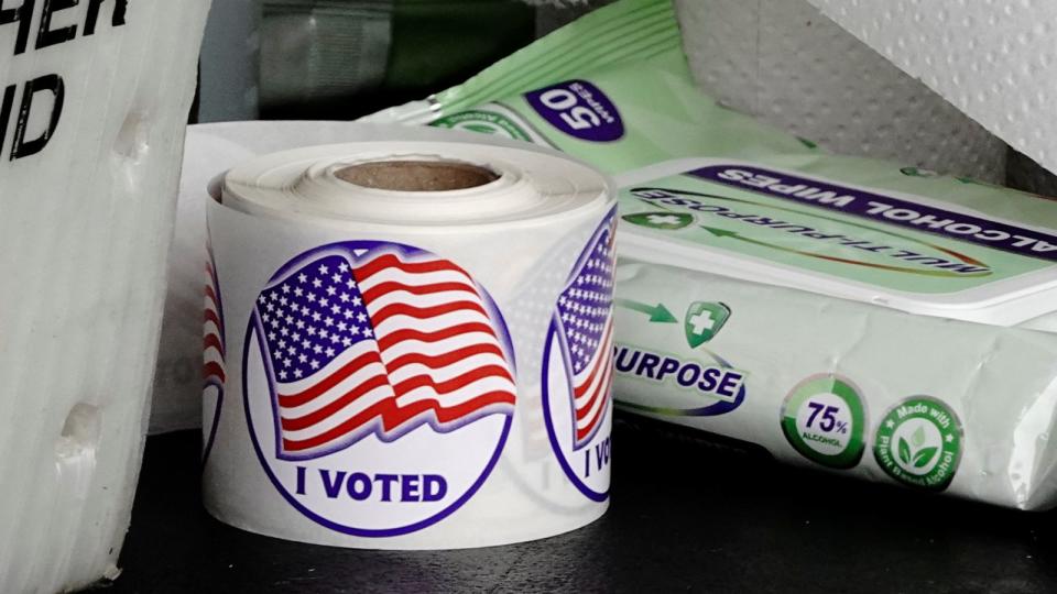PHOTO: A roll of 'I Voted' stickers is seen next to a packet of alcohol wipes at a drive-thru early voting site in the City Hall parking lot in Eau Claire, Wis., Oct. 23, 2020.  (Bing Guan/Reuters)