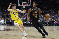 Cleveland Cavaliers guard Donovan Mitchell (45) drives against Los Angeles Lakers guard Austin Reaves (15) during the second half of an NBA basketball game Tuesday, Dec. 6, 2022, in Cleveland. (AP Photo/Ron Schwane)