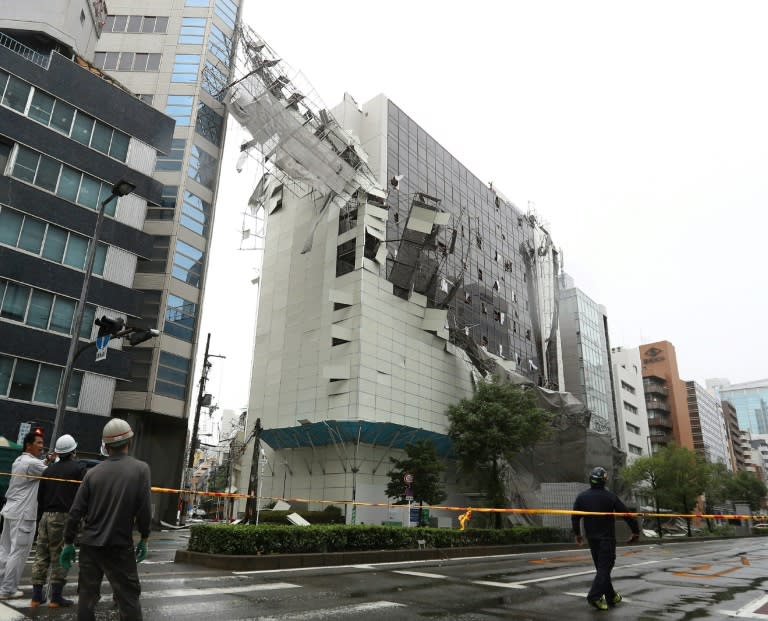 Scaffolding is torn off a building in Osaka raked by the high winds