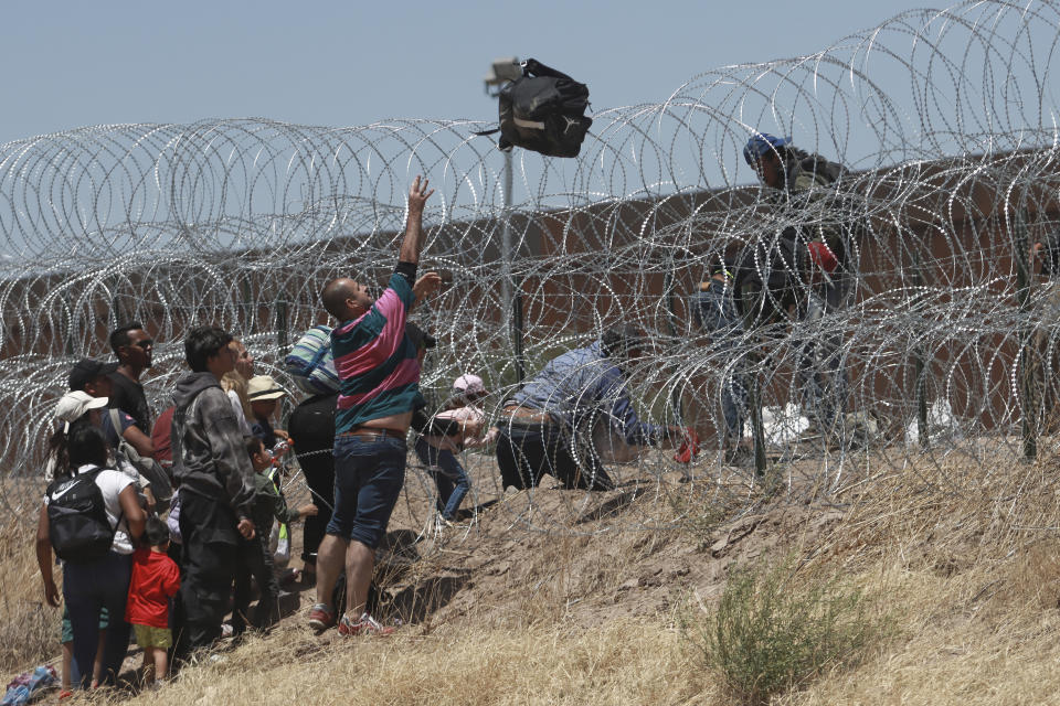 FILE - Migrants cross a barbed-wire barrier at the US-Mexico border, as seen from Ciudad Juarez, Mexico, Thursday, May 11, 2023. Migrants rushed across the Mexico border in hopes of entering the U.S. in the final hours before pandemic-related asylum restrictions are lifted. (AP Photo/Christian Chavez, File)