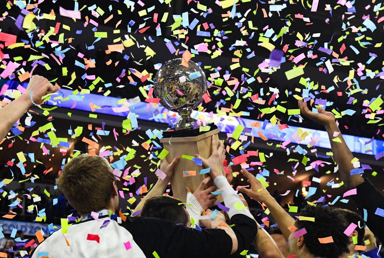 The South Dakota State men's basketball team holds the Summit League trophy as confetti falls onto them on Tuesday, March 8, 2022, at the Denny Sanford Premier Center in Sioux Falls.
