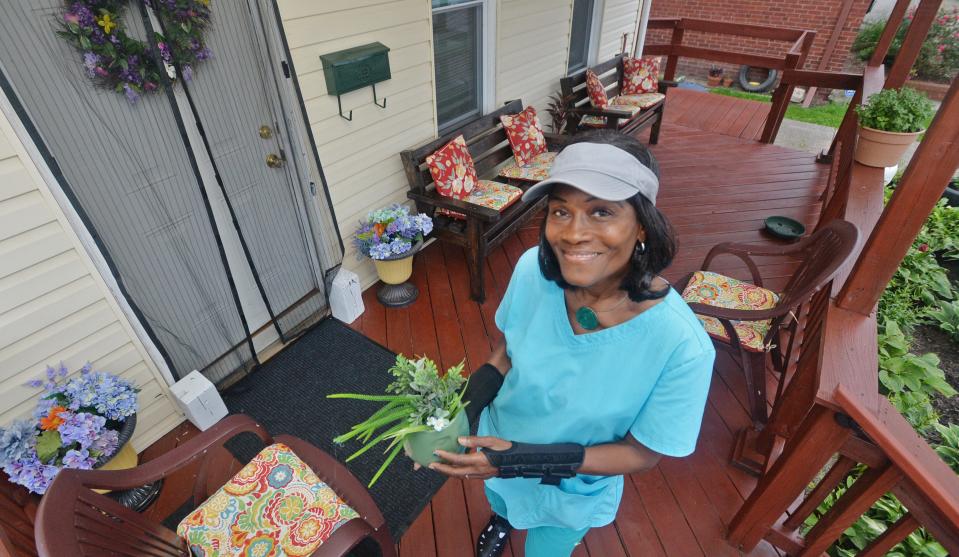 Patricia Poston stands on her front porch, recently painted through the City of Erie's "Love Your Block" program, in the 900 block of East Ninth Street in Erie. Poston, 71, encouraged many of her neighbors to apply for the beautification grants as well.