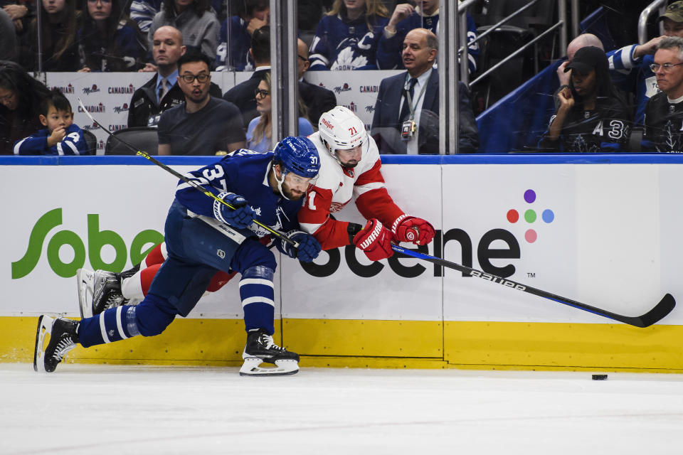 Toronto Maple Leafs defenseman Timothy Liljegren (37) checks Detroit Red Wings defenseman Filip Hronek (17) into the boards during the third period of an NHL hockey game Saturday, Jan. 7, 2023, in Toronto. (Christopher Katsarov/The Canadian Press via AP)