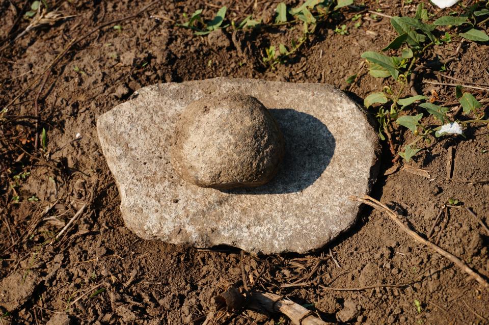 A round rock on top of a flatter rock