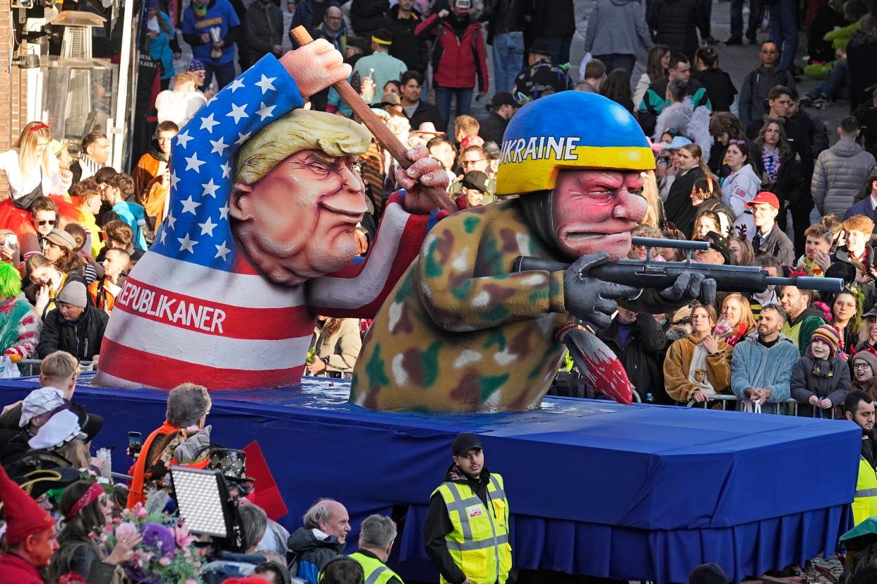 Another float shows the former president stabbing a Ukrainian soldier in the back (AP)