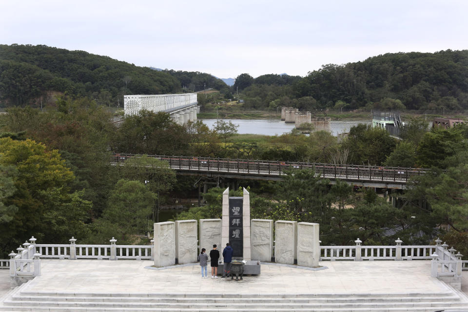 South Korean visitors pay respect to their ancestors in North Korea to celebrate the Chuseok, the Korean version of Thanksgiving Day, at Imjingak Pavilion in Paju, near the border with North Korea, South Korea, Thursday, Oct. 1, 2020. The government has discouraged people from visiting their hometowns for the Chuseok holiday amid concerns about the spread of the coronavirus. The monument reads: "Worship from a distance." (AP Photo/Ahn Young-joon)