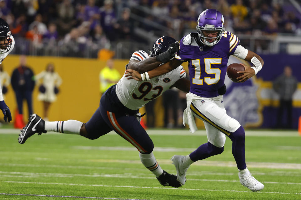 Minnesota Vikings quarterback Joshua Dobbs (15) runs from Chicago Bears defensive tackle Justin Jones (93) during the first half of an NFL football game, Monday, Nov. 27, 2023, in Minneapolis. (AP Photo/Bruce Kluckhohn)