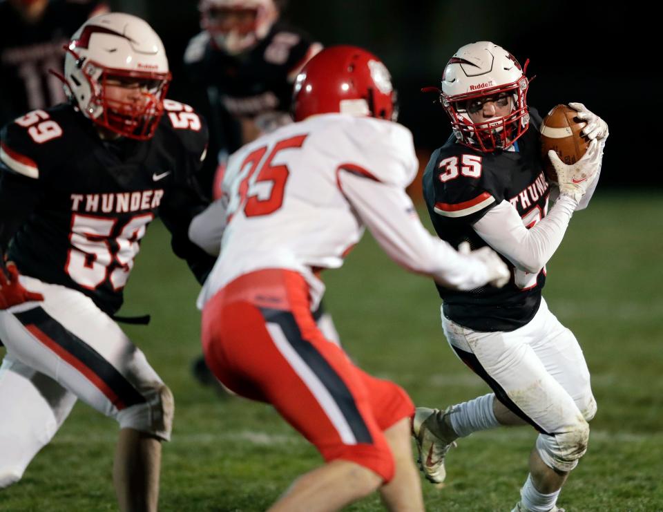 Seymour's Carson Molle (35) runs for a gain after a catch against New London's Garrison Gregory (35) as Reid Huss (59) looks to block during their football game Oct. 30 in Seymour.