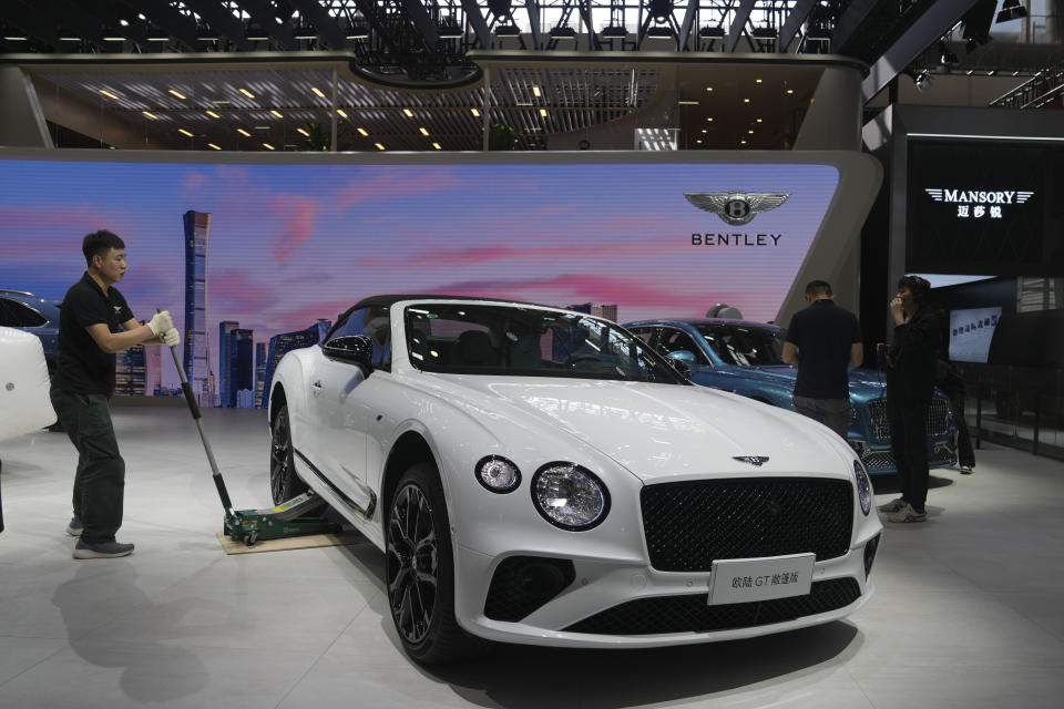 A worker prepares at a Bentley booth for the upcoming auto show to be held in Beijing, China, Wednesday, April 24, 2024. Foreign automakers have been caught flat-footed in China by an electric vehicle boom that has shaken up the market over the last three years. That has left manufacturers like Volkswagen scrambling to develop new models for a very different market than at home. (AP Photo/Tatan Syuflana)