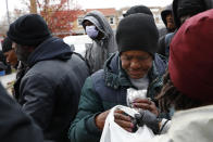 In this March 25, 2020, photo, a woman is among dozens crowding in line for a bag of fresh produce despite the efforts of volunteers to space them out, during a delivery of food donations in southeast Washington. Neighborhood deliveries are part of a new Martha's Table initiative, along with community partners, to get needed food directly to the neighborhoods they serve. Local volunteers are the tip of the spear for a grassroots community effort to keep Washington's most vulnerable neighborhoods fed during the unprecedented coronavirus crisis which has nearly shut down the American economy. (AP Photo/Jacquelyn Martin)