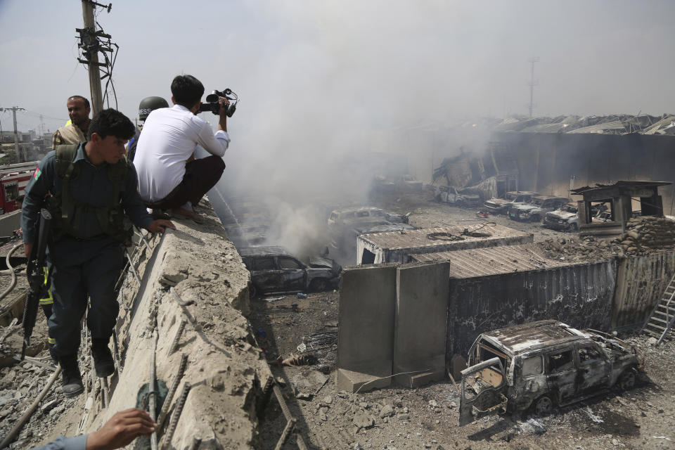 A journalist records the video from inside the Green Village compound after the residents protest in Kabul, Afghanistan, Tuesday, Sept. 3, 2019. The attack occurred late Monday near the the Green Village, home to several international organizations and guesthouses. (AP Photo/Rahmat Gul)