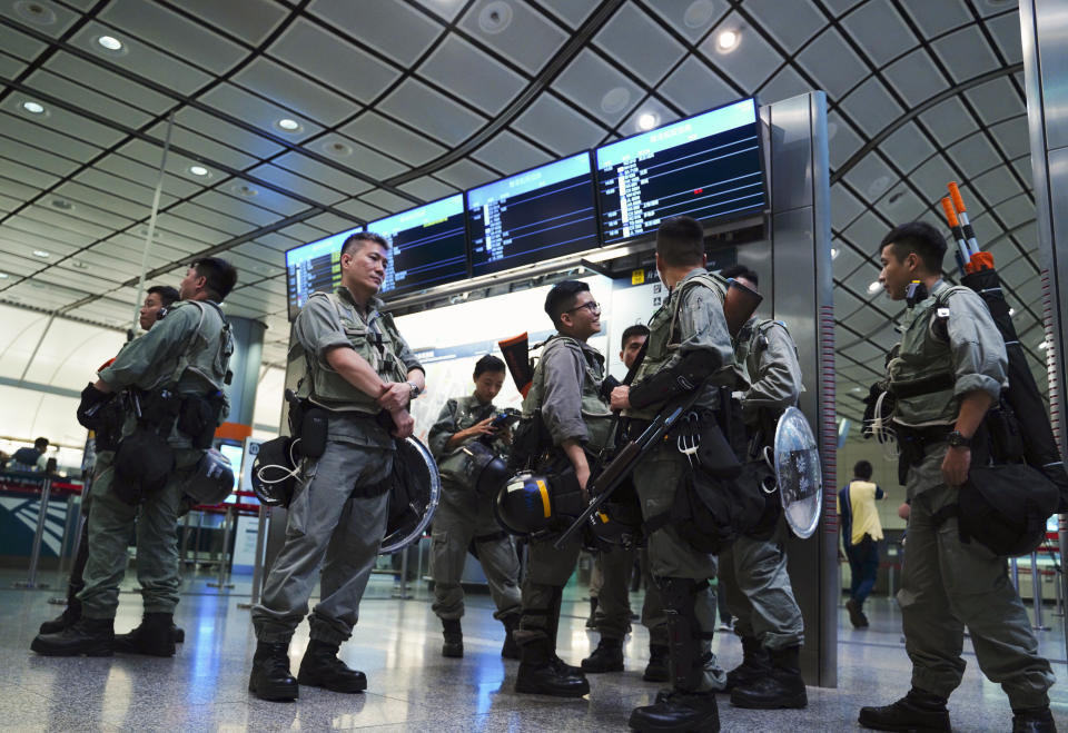 Riot police stand guard at airport express central station in downtown Hong Kong, Saturday, Sept. 7, 2019. Hong Kong authorities were limiting airport transport services and controlling access to terminals Saturday as they braced for a second weekend of disruption following overnight demonstrations that turned violent. (AP Photo/Vincent Yu)