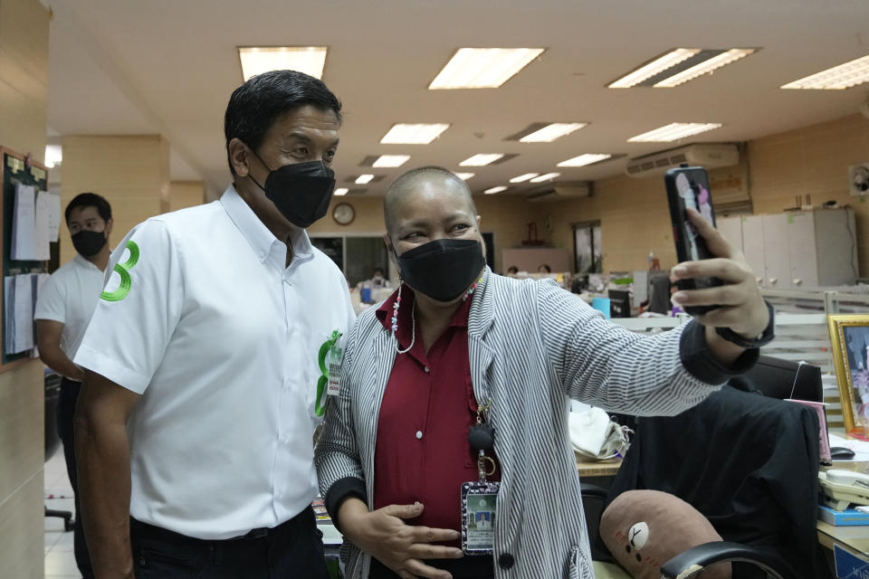 FILE - A supporter takes a selfie with Bangkok governor independent candidate Chadchart Sittipunt, left, during an election campaign in Bangkok, Thailand on May 17, 2022. Residents of the Thai capital Bangkok, in their first opportunity in nine years to vote for their city's governor, have elected Chadchart an independent politician seen as representing opponents of the country's military-backed new government, results released early Monday showed. (AP Photo/Sakchai Lalit, file)