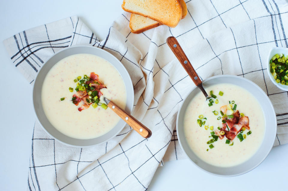 Two bowls of potato cream soup with bacon and green onion.