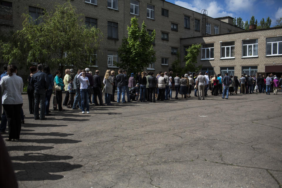 Ukrainians line up to cast their votes at a polling station in the Budennovskiy district, on the outskirts of Donetsk, Ukraine, Sunday May 11, 2014. Residents of two restive regions in eastern Ukraine engulfed by a pro-Russian insurgency are casting ballots in contentious and hastily organized independence referenda. Sunday's ballots seek approval for declaring so-called sovereign people's republics in the Donetsk and Luhansk regions, where rebels have seized government buildings and clashed with police and Ukrainian troops. (AP Photo/Manu Brabo)