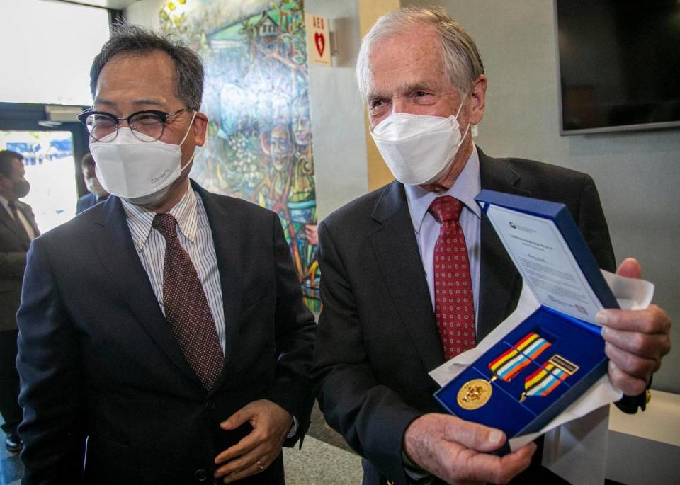 Burley Smith shows off the Ambassador for Peace medal awarded to him by the government of South Korea and presented to him by Korean Consul General Young-jun Kim, left, during a ceremony at Miami City Hall on Friday, January 22, 2021. The award commemorates the rescue of 14,000 Korean refugees by the SS Meredith Victory from the beaches of Hungnam 70 years ago. Burley Smith was a crew member aboard the Meredith Victory.