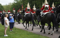 Members of the Household Cavalry make their way along the Long Walk towards Windsor Castle, Windsor, England, Saturday June 12, 2021, ahead of a ceremony to mark the official birthday of Queen Elizabeth II. (Andrew Matthews/PA via AP)