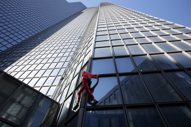 Foto del francés Alain Robert escalando el edificio de TotalEnergies en París