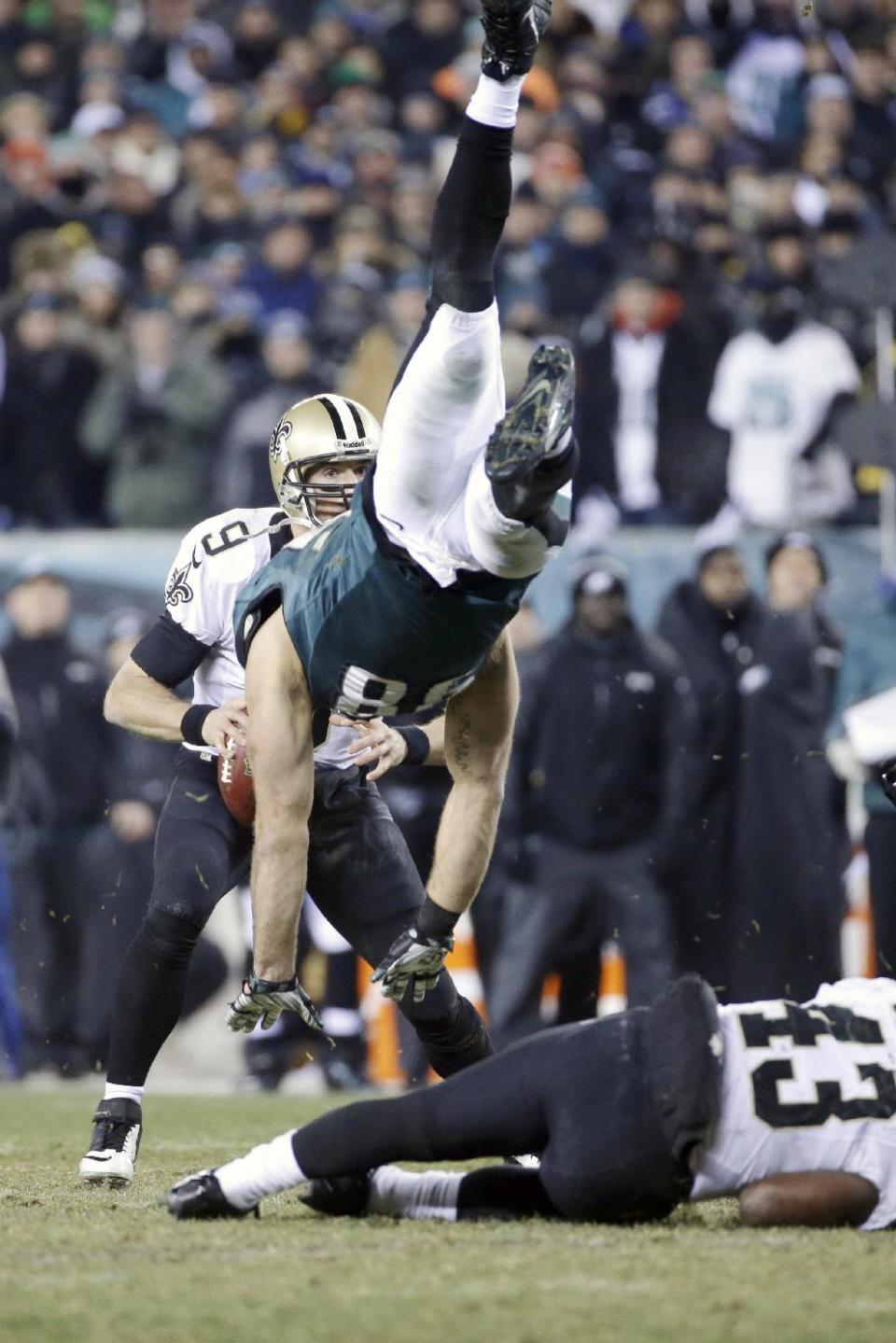 New Orleans Saints' Drew Brees, left, tries to pass as Philadelphia Eagles' Connor Barwin, center, is upended by Darren Sproles during the second half of an NFL wild-card playoff football game, Saturday, Jan. 4, 2014, in Philadelphia. (AP Photo/Matt Rourke)