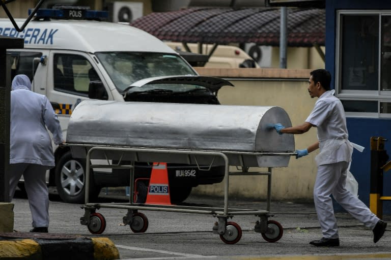 Hospital workers move a body cart to the gate of the forensics wing of the Hospital Kuala Lumpur, where the body of Kim Jong-Nam was being held, in Kuala Lumpur