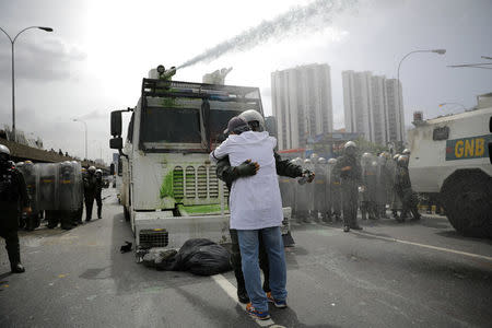 A doctor embraces a member of the Venezuelan National Guard during a rally called by health care workers and opposition activists against Venezuela's President Nicolas Maduro in Caracas, Venezuela May 22, 2017. REUTERS/Carlos Barria