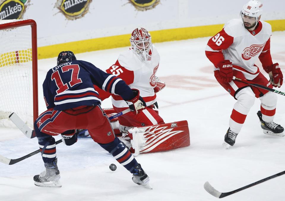 Detroit Red Wings goaltender Magnus Hellberg (45) saves a shot by Winnipeg Jets' Adam Lowry (17) during first-period NHL hockey game action in Winnipeg, Manitoba, Friday, March 31, 2023. (John Woods/The Canadian Press via AP)