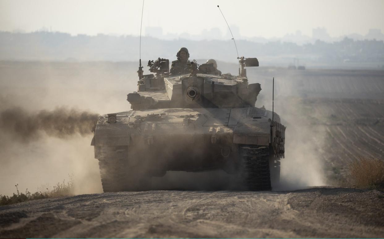 An Israeli tank moves along the border with Gaza