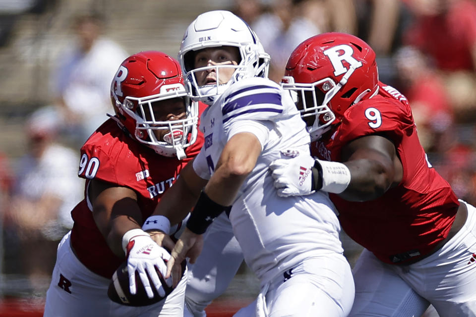 Northwestern quarterback Ben Bryant (2) is pressured by Rutgers defensive lineman Isaiah Iton (9) and has the ball knocked away by Rene Konga (90) during the first half of an NCAA college football game, Sunday, Sept. 3, 2023, in Piscataway, N.J. (AP Photo/Adam Hunger)
