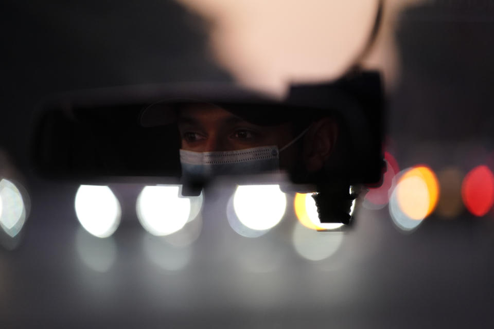 Emergency medical technician Joshua Hammond, 25, of Emergency Ambulance Service, drives an ambulance to his station in Placentia, Calif. Friday, Jan. 8, 2021. (AP Photo/Jae C. Hong)