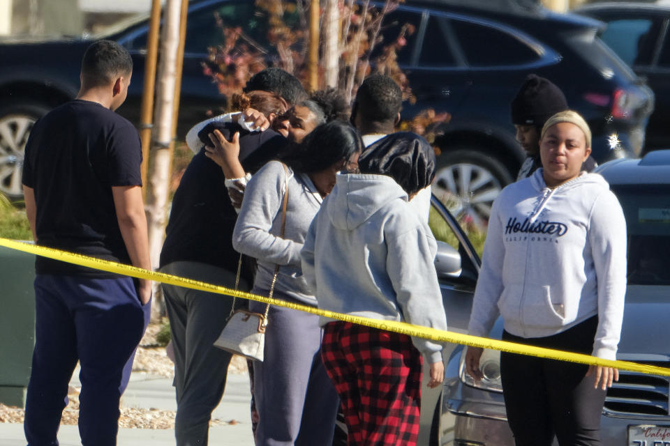 Neighbors react near a home where five bodies were found dead, in the city of Lancaster in the high desert Antelope Valley north of Los Angeles, Monday, Nov. 29, 2021. A Los Angeles County Sheriff's Department statement says deputies found a woman, a girl and three boys with gunshot wounds and paramedics pronounced them dead at the scene. The department says the children's father showed up at the Lancaster sheriff's station and was arrested on suspicion of five murders after being interviewed by detectives. (AP Photo/Ringo H.W. Chiu)