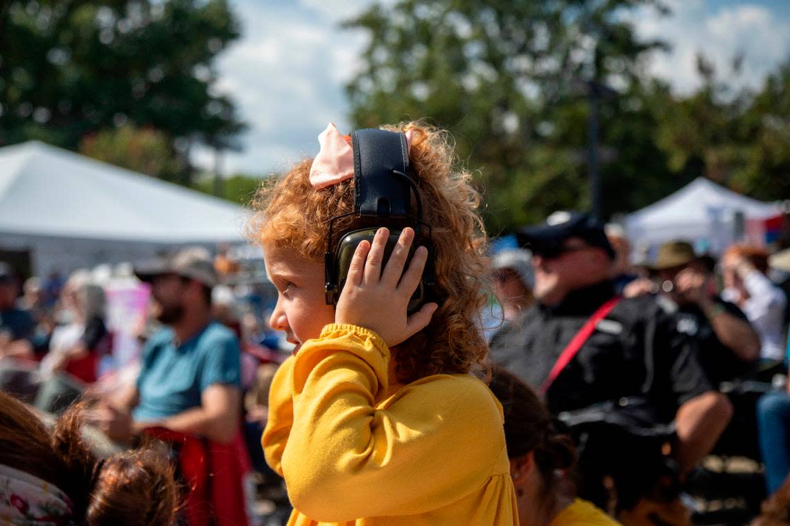 Emery Warner, 3, wears hearing protection as the Chatham Rabbits perform outside the Duke Energy Center for the Performing Arts during the IBMA World of Bluegrass festival in downtown Raleigh Friday, Oct. 1, 2021.