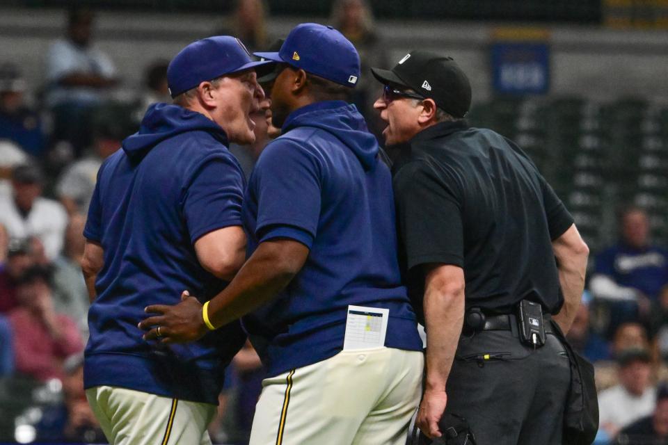 Brewers assistant manager Rickie Weeks, center, tries to hold back manager Pat Murphy while he argues with home plate umpire Chros Guccione in the sixth inning against the Tampa Bay Rays at American Family Field last Tuesday.