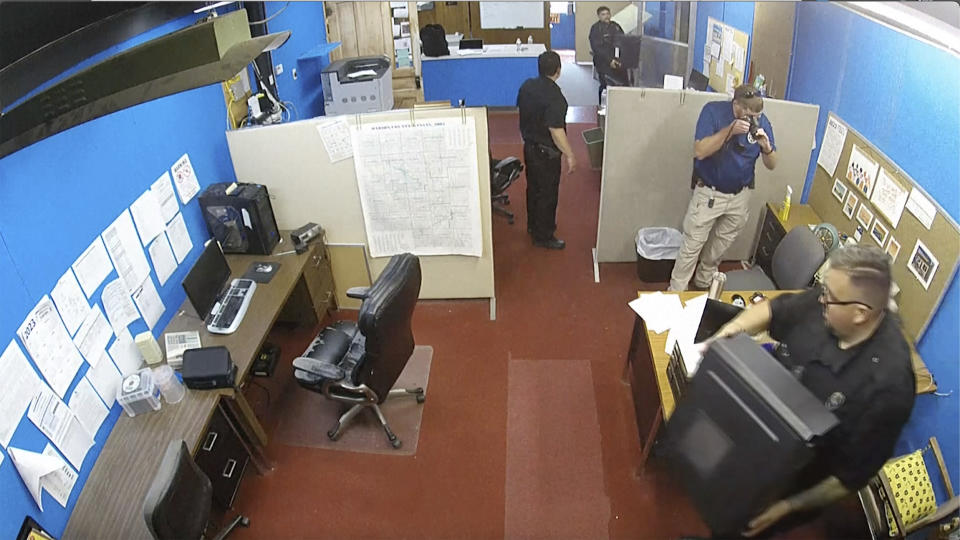 This surveillance video shows Marion Police Department confiscating computers and cellphones from the publisher and staff of the Marion County Record on Friday, Aug. 11, 2023 in Marion, Kan. The small newspaper and the police department in Kansas are at the center of a dispute over freedom of speech that is being watched around the country after police raided the office of the local newspaper and the home of its owner and publisher. (Marion County Record via AP)