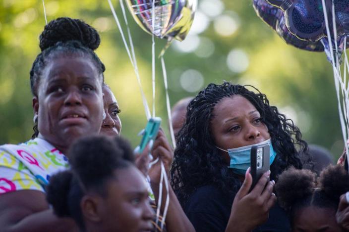 Friends and family members listen to Quiana Martin speaks about the life of her mother, Shirley Muhammad during the vigil to celebrate her life and the lives of Jaelin Ransom and Tyla Ransom, Thursday, July 29, 2021 at Stanford Brown Park in Kansas City. Friends and family gathered to let go of balloons and celebrate their loved ones lives.