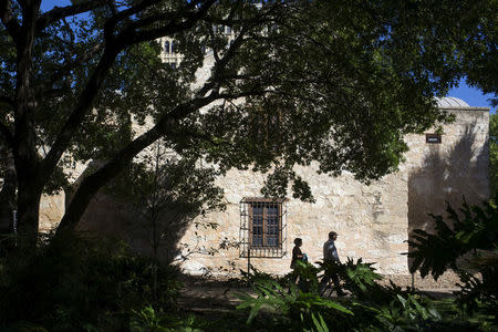 FILE PHOTO - Visitors walk past the walls of the church at the Alamo, which is on the UNESCO World Heritage Cultural List, in San Antonio, Texas, U.S. on October 26, 2015. REUTERS/Adrees Latif/File Photo