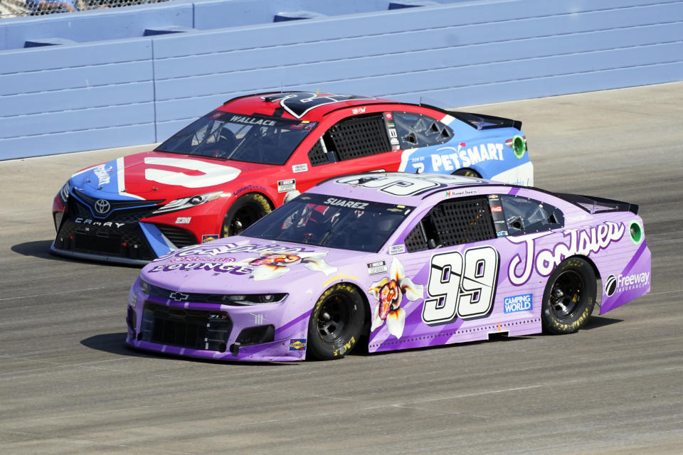 Daniel Suarez (99) leads Bubba Wallace (23) during a NASCAR Cup Series auto race Sunday, June 20, 2021, in Lebanon, Tenn. (AP Photo/Mark Humphrey)