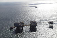 This aerial photograph shows an oil rig damaged from an explosion and fire in the Gulf of Mexico, about 25 miles southeast of Grand Isle, La., Friday, Nov. 16, 2012. Four people were transported to a hospital with critical burns and two were missing. (AP Photo/Gerald Herbert)