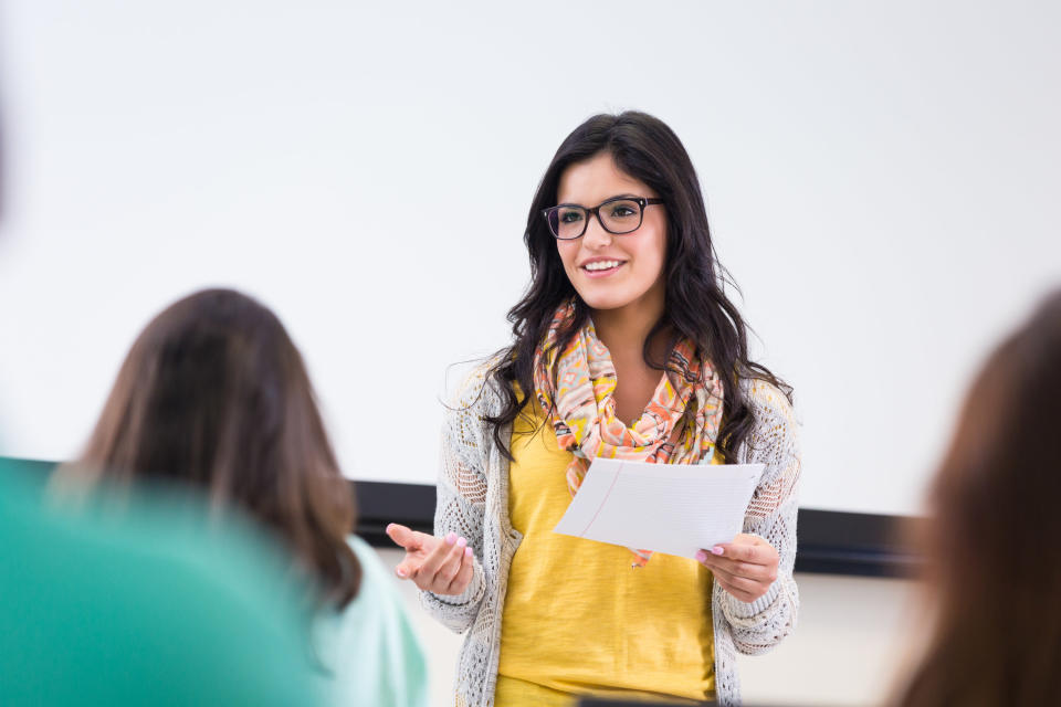 A student reads a paper in front of the class