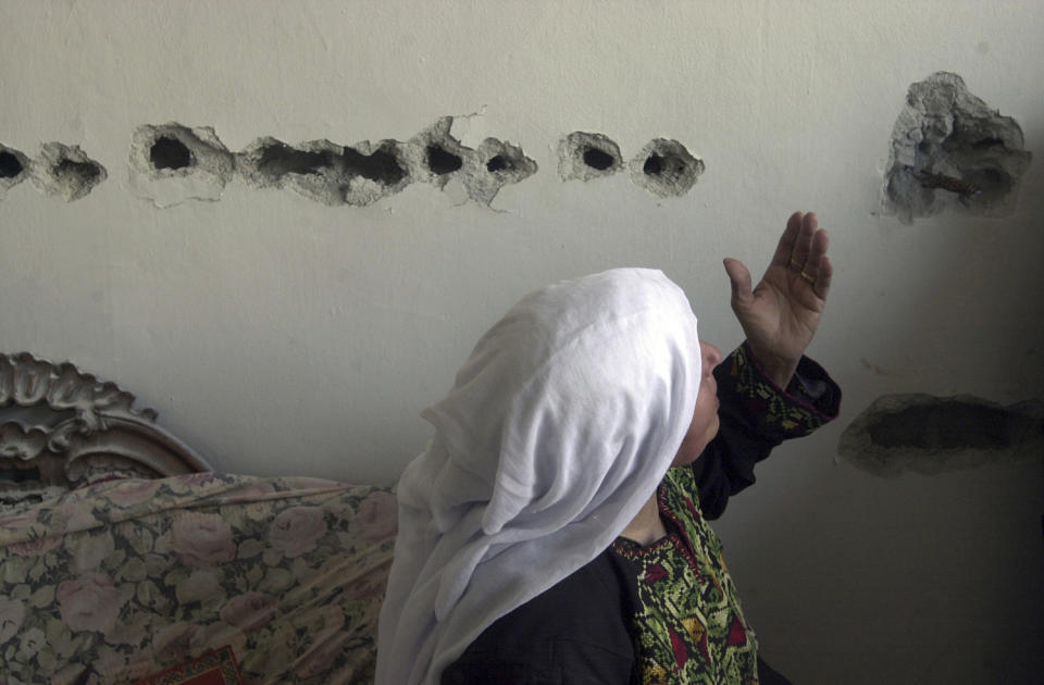 <p>A Palestinian woman gestures in front of a wall riddled with heavy machine-gun fire from an Israeli tank outside the Paradise hotel on Nativity Road in the West Bank town of Bethlehem, Oct. 29, 2001. (Photo: Jacqueline Larma/AP) </p>