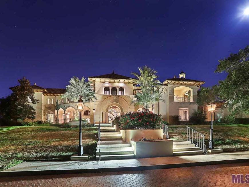 House shown at night with palm trees in front in Louisiana