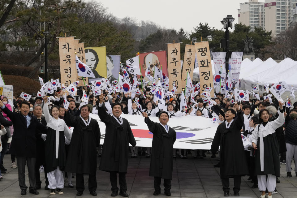 South Koreans give three cheers for the country as they march during a ceremony to celebrate the March First Independence Movement Day, the anniversary of the 1919 uprising against Japanese colonial rule, in Seoul, South Korea, Wednesday, March 1, 2023. (AP Photo/Ahn Young-joon)